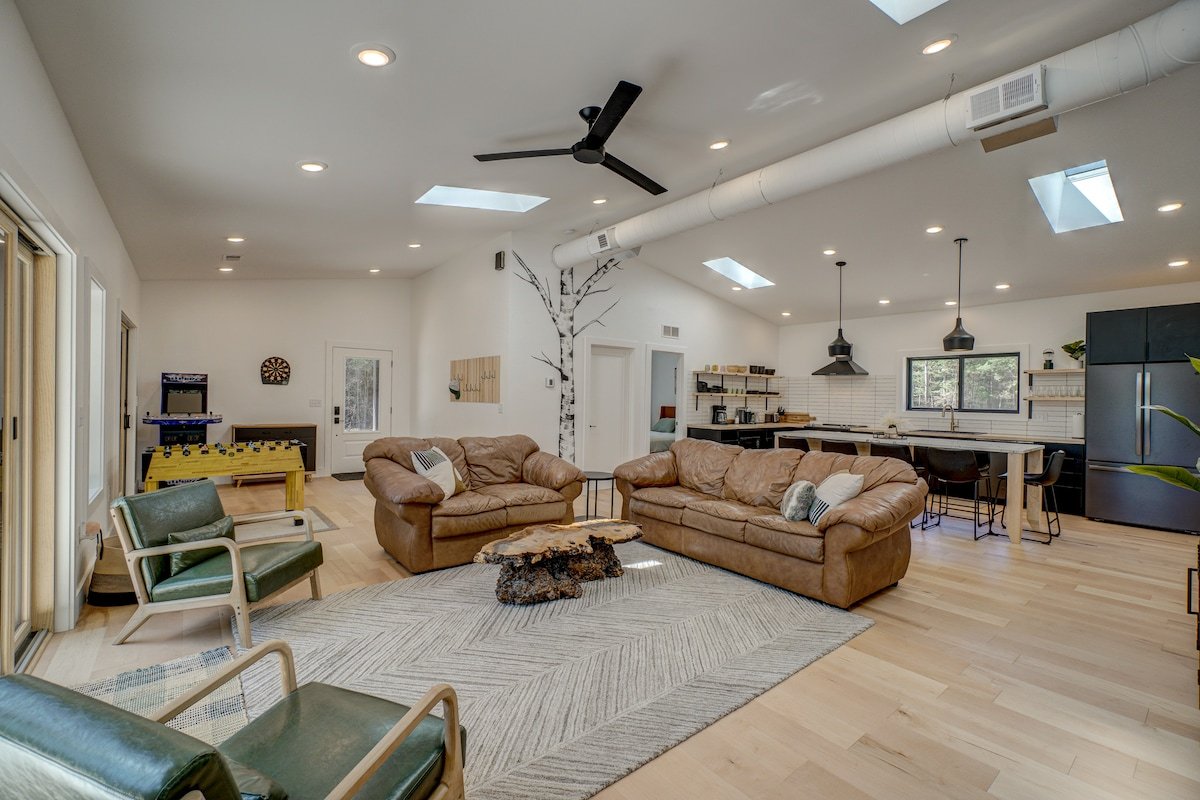 Bright open living room with leather sofas and skylights