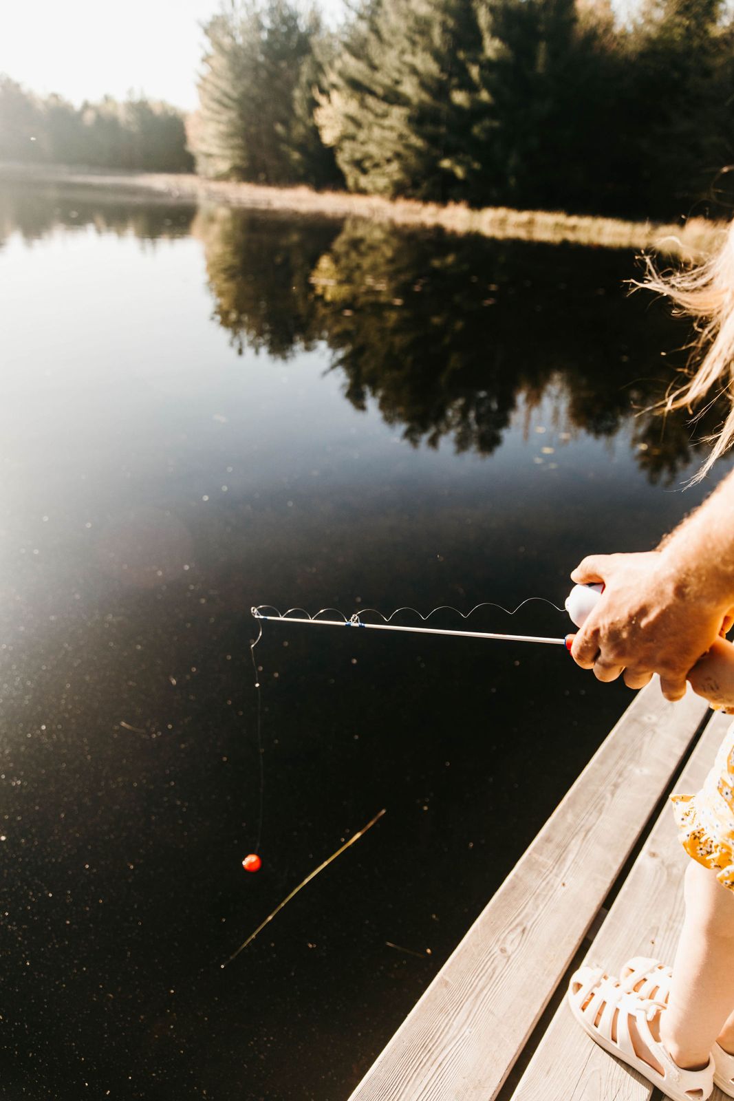 Fishing off the dock on a calm summer morning at Cornerstone Cabin